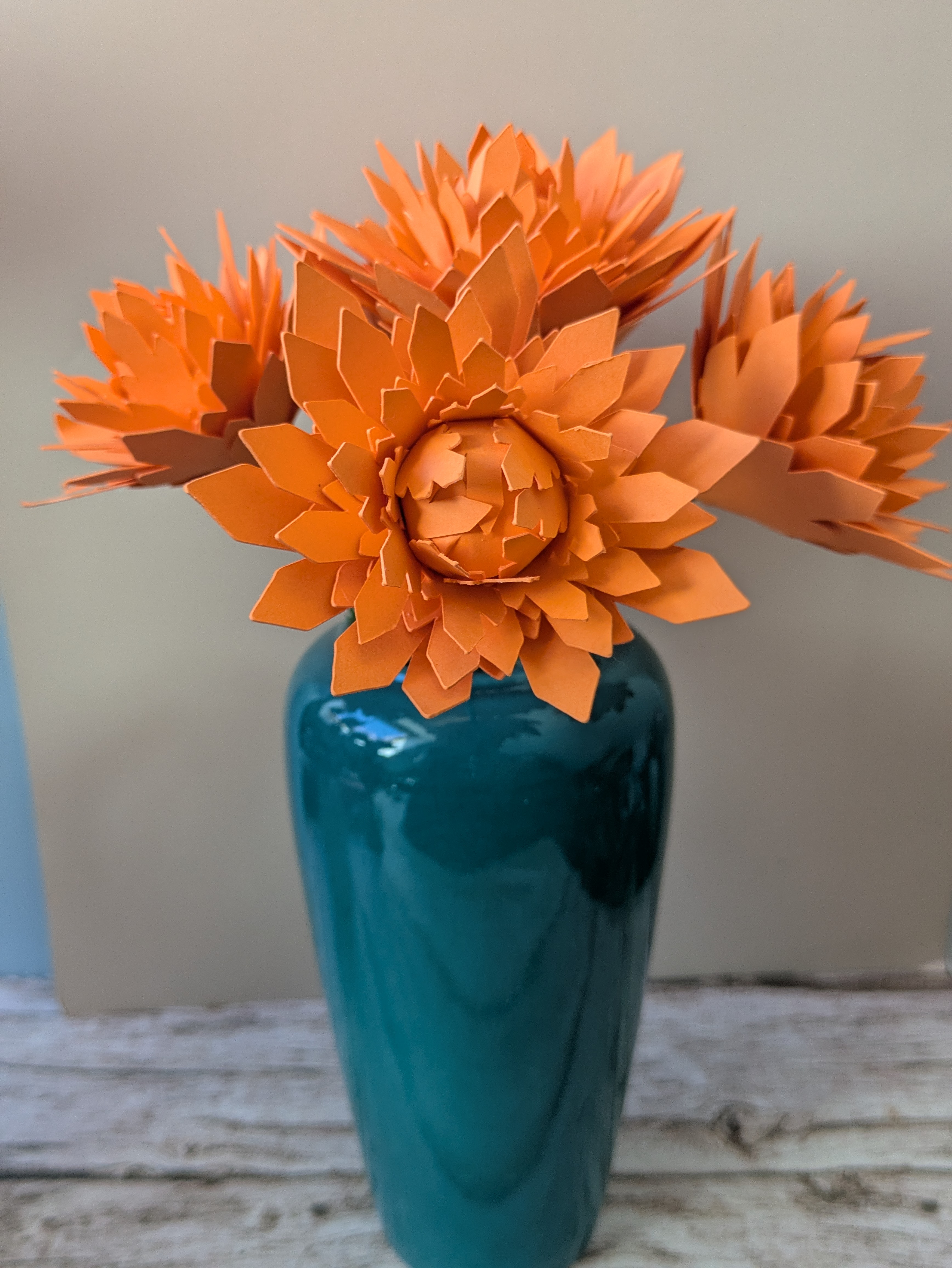Bouquet de dahlias orange vase bleu